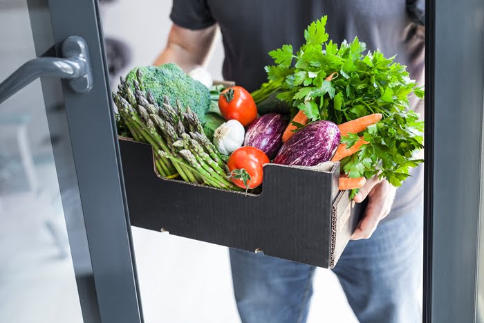 Vendedor com verduras de porta em porta